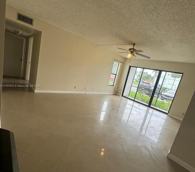 3664 Alder Dr Unit B1, West Palm Beach, FL 33417 - empty room featuring a ceiling fan, baseboards, a textured ceiling, and light tile patterned floors