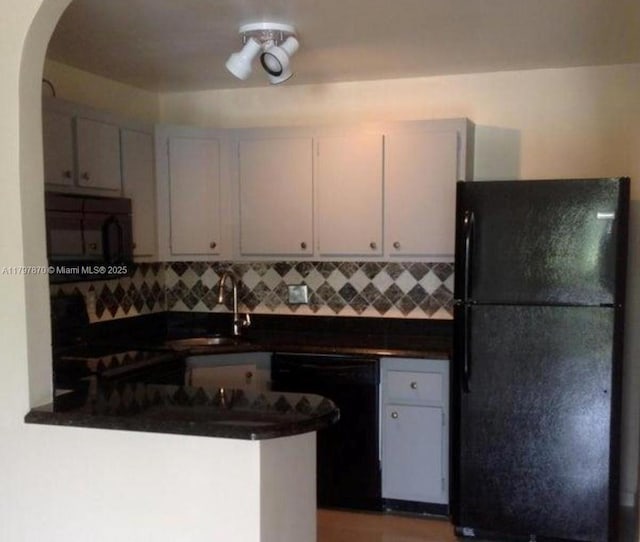 3664 Alder Dr Unit B1, West Palm Beach, FL 33417 - kitchen featuring black appliances, dark countertops, a sink, and tasteful backsplash