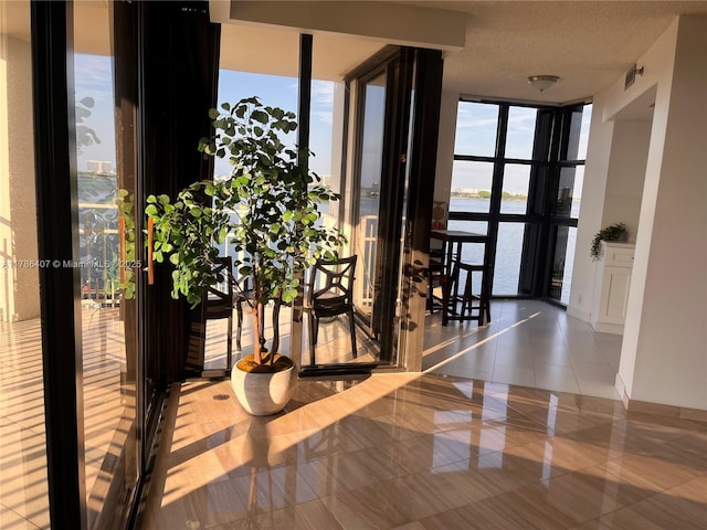 4000 NE Towwerside Ter Unit 1101, Miami, FL 33138 - corridor with expansive windows, a water view, and tile patterned flooring