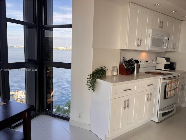 4000 NE Towwerside Ter Unit 1101, Miami, FL 33138 - kitchen featuring white appliances, light tile patterned floors, white cabinets, light countertops, and recessed lighting