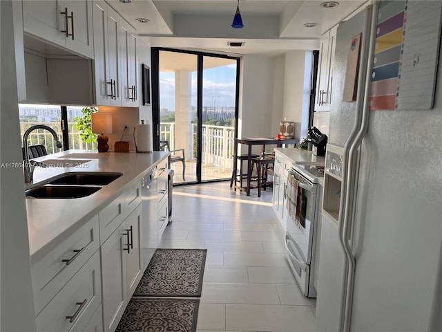 4000 NE Towwerside Ter Unit 1101, Miami, FL 33138 - kitchen featuring white appliances, a sink, light countertops, expansive windows, and decorative light fixtures