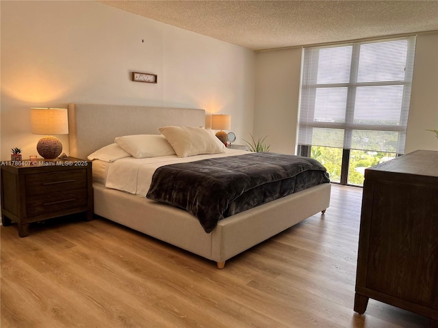 4000 NE Towwerside Ter Unit 1101, Miami, FL 33138 - bedroom featuring a textured ceiling, light wood-style flooring, and expansive windows