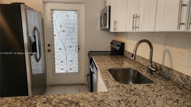 981 Hillcrest Ct Unit 114, Hollywood, FL 33021 - kitchen featuring appliances with stainless steel finishes, a sink, white cabinetry, tasteful backsplash, and light stone countertops