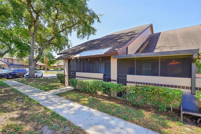 2323 NW 37th Ave, Coconut Creek, FL 33066 - view of side of property featuring a sunroom, roof with shingles, and stucco siding