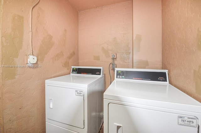 1141 Lake Victoria Dr Unit E, West Palm Beach, FL 33411 - laundry area with washing machine and clothes dryer and a textured wall