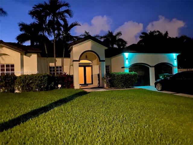 13135 SW 218th Ter, Miami, FL 33170 - mediterranean / spanish-style home featuring an attached garage, a front yard, stucco siding, and driveway