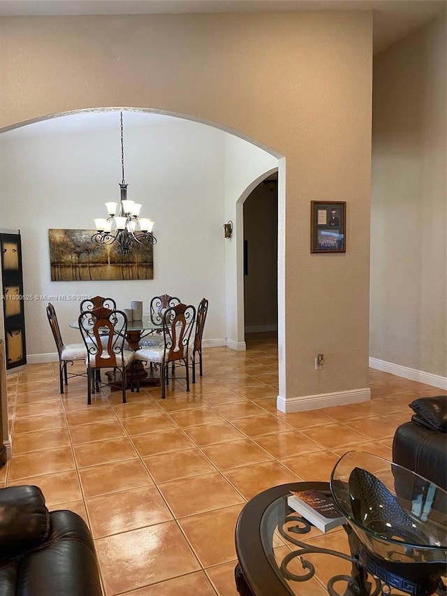 13135 SW 218th Ter, Miami, FL 33170 - dining room with arched walkways, a chandelier, light tile patterned flooring, and baseboards