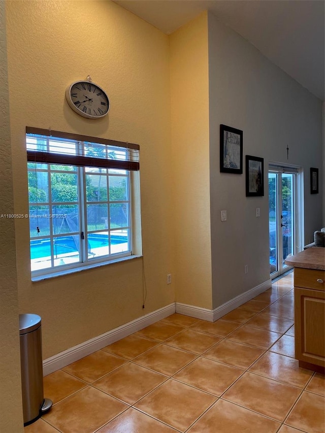 13135 SW 218th Ter, Miami, FL 33170 - interior space featuring light tile patterned floors, a textured wall, baseboards, and lofted ceiling
