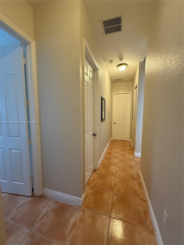 13135 SW 218th Ter, Miami, FL 33170 - hall featuring light tile patterned flooring, a textured wall, and baseboards