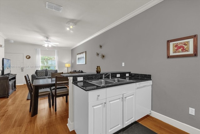 2950 Lucayan Harbour Cir Unit 107, Kissimmee, FL 34746 - kitchen featuring a sink, dishwasher, a peninsula, light wood-style flooring, and ornamental molding