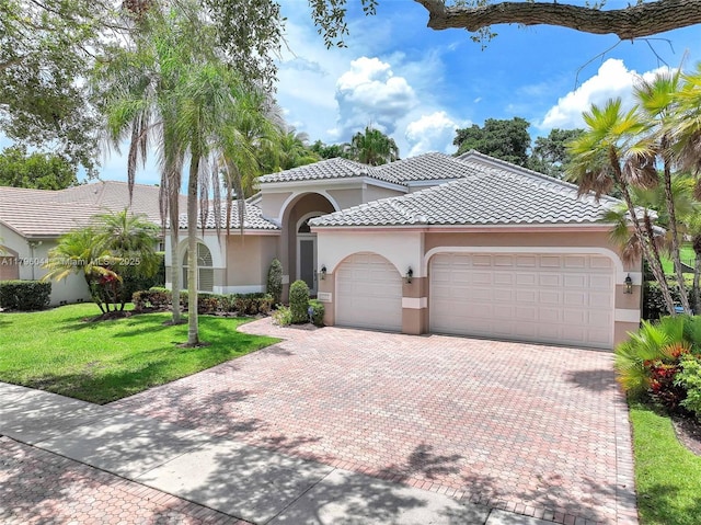 2623 Oakbrook Dr, Weston, FL 33332 - mediterranean / spanish-style house with an attached garage, stucco siding, decorative driveway, and a front lawn
