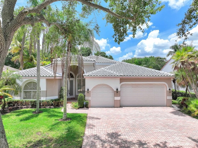 2623 Oakbrook Dr, Weston, FL 33332 - mediterranean / spanish home with a garage, decorative driveway, stucco siding, and a tile roof