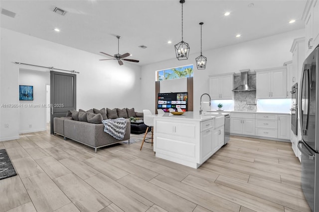 2623 Oakbrook Dr, Weston, FL 33332 - kitchen with wall chimney exhaust hood, stainless steel appliances, ceiling fan, a barn door, and open floor plan