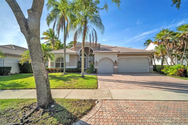 2623 Oakbrook Dr, Weston, FL 33332 - view of front of house featuring an attached garage, decorative driveway, stucco siding, and a front lawn
