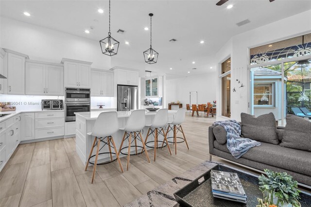 2623 Oakbrook Dr, Weston, FL 33332 - kitchen featuring appliances with stainless steel finishes, open floor plan, light countertops, recessed lighting, and a kitchen island with sink
