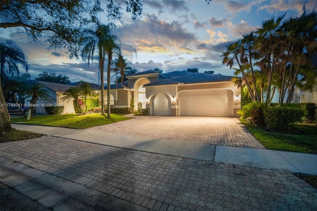 2623 Oakbrook Dr, Weston, FL 33332 - mediterranean / spanish-style home featuring stucco siding, decorative driveway, a garage, and a yard
