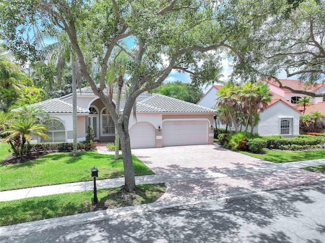 2623 Oakbrook Dr, Weston, FL 33332 - view of front facade with an attached garage, driveway, a front lawn, stucco siding, and a tiled roof