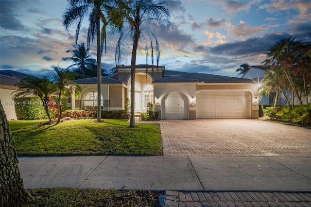 2623 Oakbrook Dr, Weston, FL 33332 - view of front of property featuring stucco siding, decorative driveway, a garage, and a lawn