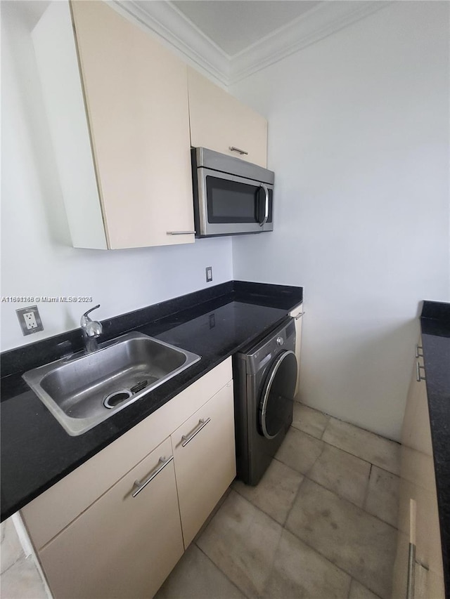 928 Jefferson Ave Unit 6, Miami Beach, FL 33139 - kitchen with stainless steel microwave, washer / dryer, a sink, ornamental molding, and dark countertops