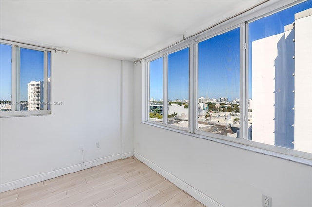 1345 Lincoln Unit 1006, Miami Beach, FL 33139 - unfurnished room featuring a city view, wood finished floors, and baseboards