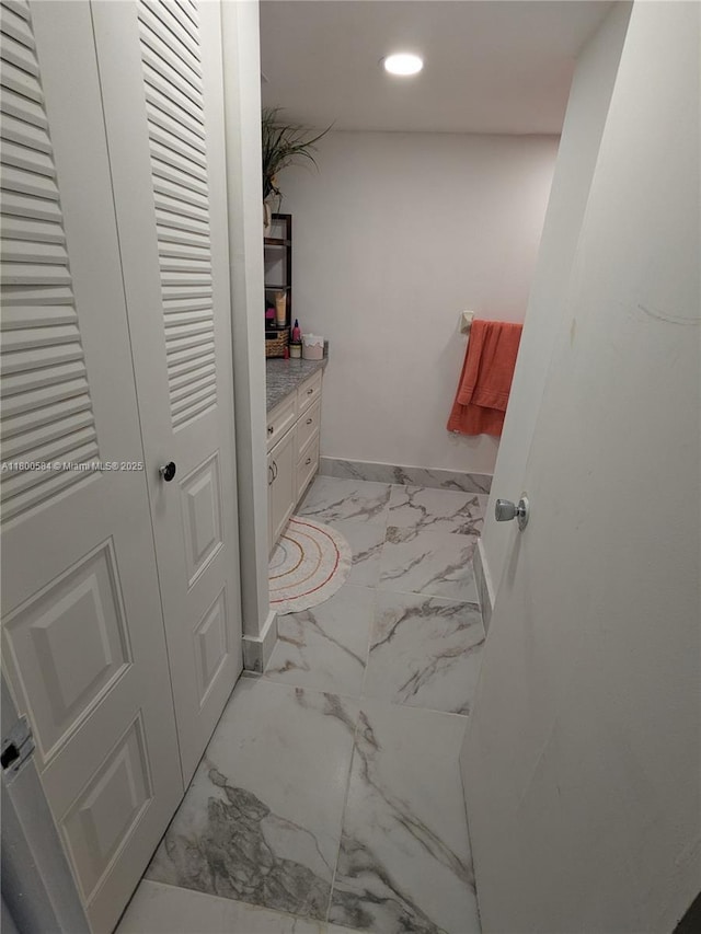 bathroom with marble look tiles, recessed lighting, and baseboards