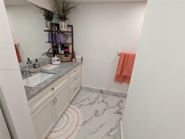 bathroom with marble finish flooring, vanity, and baseboards