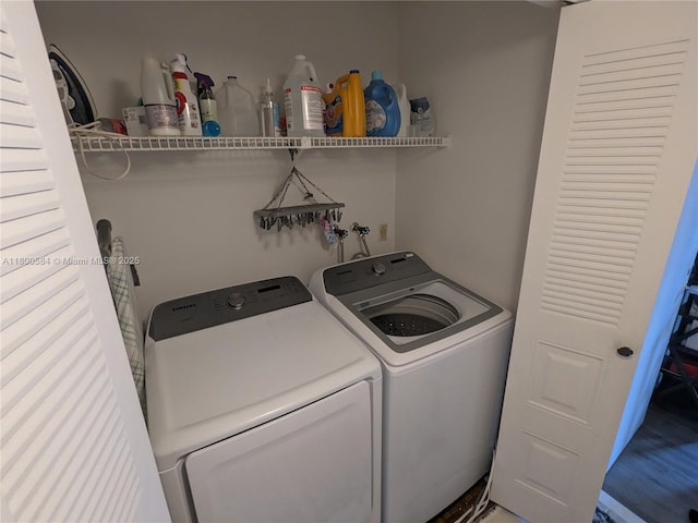 washroom with washer and dryer and wood finished floors