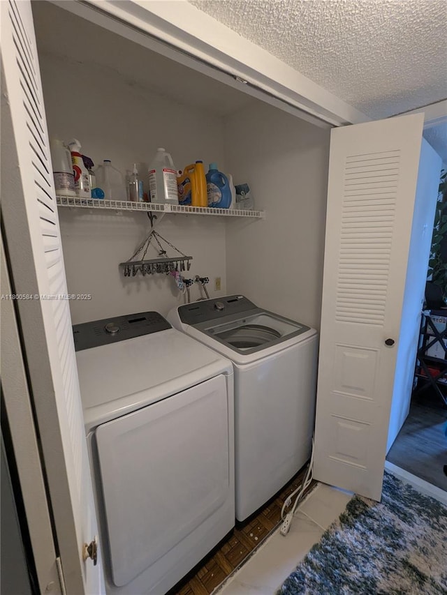 washroom with washing machine and dryer and a textured ceiling