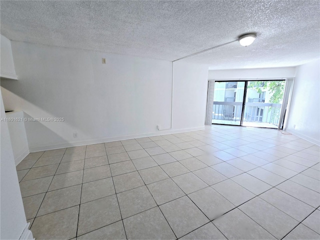 1850 N Congress Ave Unit 311, West Palm Beach, FL 33401 - unfurnished room featuring a textured ceiling, baseboards, and light tile patterned floors