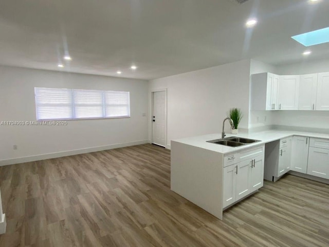22011 Catherine Prt, Charlotte, FL 33952 - kitchen with a sink, a skylight, light wood-type flooring, light countertops, and recessed lighting