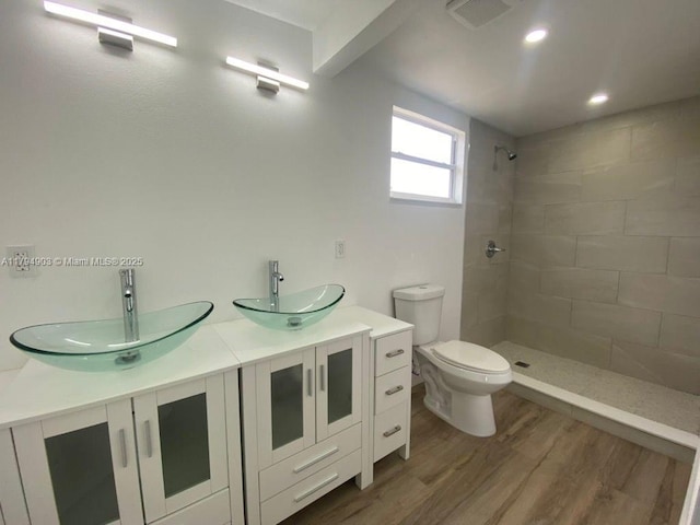 22011 Catherine Prt, Charlotte, FL 33952 - full bath featuring a tile shower, toilet, wood finished floors, double vanity, and recessed lighting