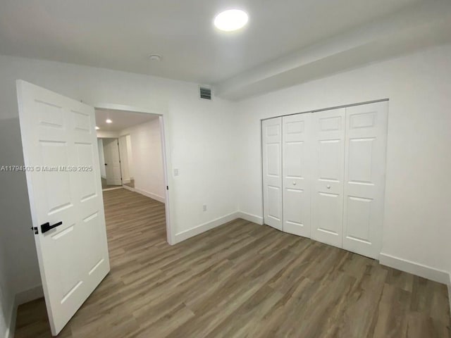 22011 Catherine Prt, Charlotte, FL 33952 - unfurnished bedroom with baseboards, wood finished floors, a closet, and recessed lighting