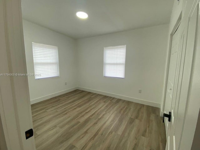 22011 Catherine Prt, Charlotte, FL 33952 - unfurnished bedroom with multiple windows, baseboards, and light wood-style floors