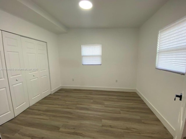 22011 Catherine Prt, Charlotte, FL 33952 - unfurnished bedroom with wood finished floors, a closet, and baseboards