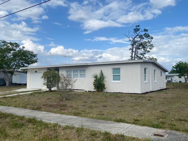 22011 Catherine Prt, Charlotte, FL 33952 - view of side of home featuring an attached garage, stucco siding, a yard, and driveway