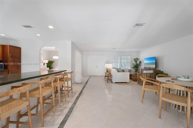 living area with arched walkways, recessed lighting, and inlaid floor details