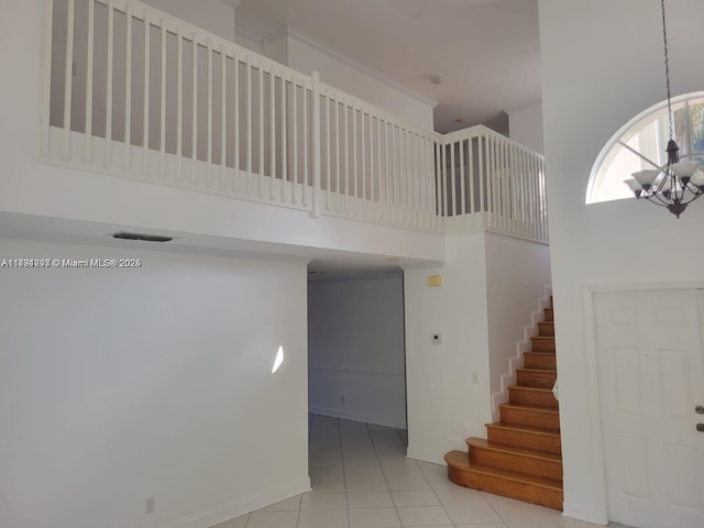 8021 Stirrup Cay Ct, Boynton Beach, FL 33436 - stairway with a towering ceiling, tile patterned floors, a chandelier, and baseboards