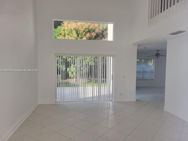 8021 Stirrup Cay Ct, Boynton Beach, FL 33436 - empty room with a towering ceiling, light tile patterned floors, a ceiling fan, and baseboards