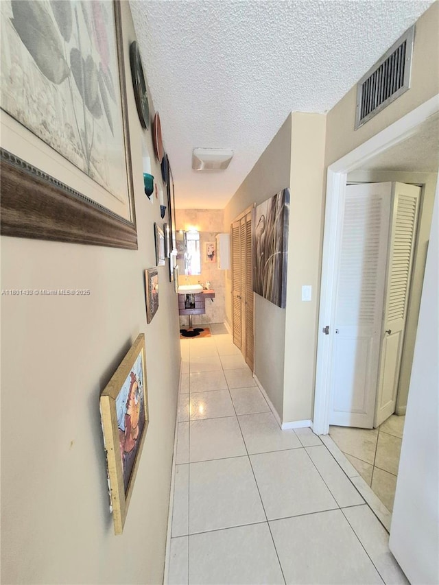 3800 S Ocean Dr Unit 818, Hollywood, FL 33019 - hall featuring light tile patterned floors, a textured ceiling, and baseboards