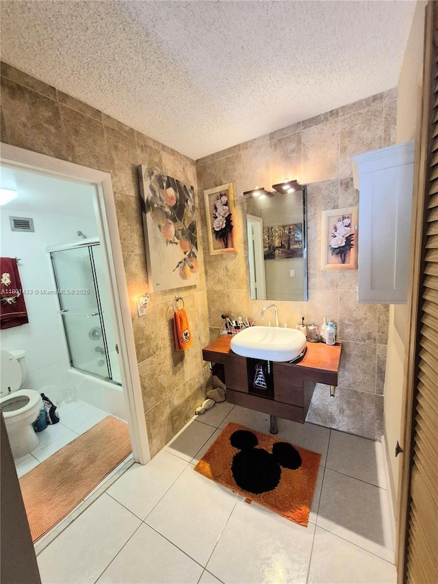 3800 S Ocean Dr Unit 818, Hollywood, FL 33019 - full bath with tile walls, a sink, a shower with door, tile patterned flooring, and a textured ceiling