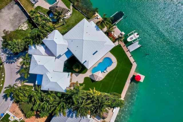 drone / aerial view of a pool area and a large body of water