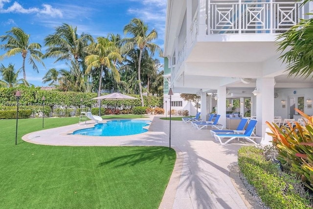 outdoor pool with a patio and a yard