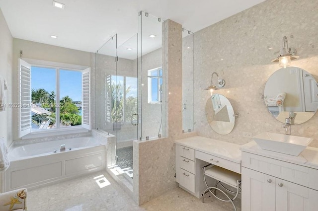 bathroom with healthy amount of natural light, a stall shower, a bath, and vanity