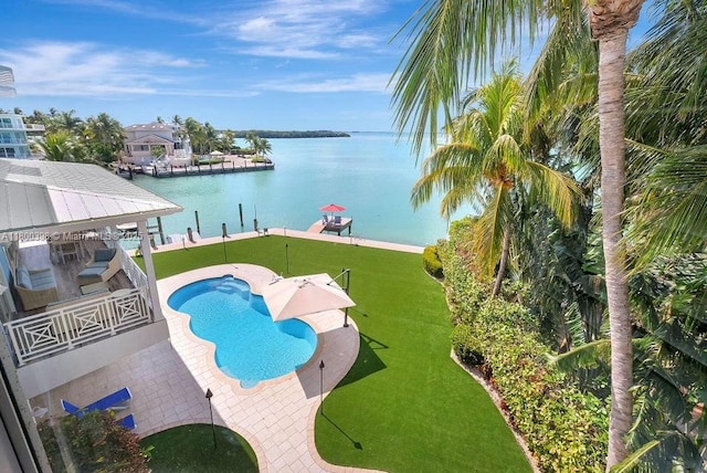 view of pool with a water view and a lawn
