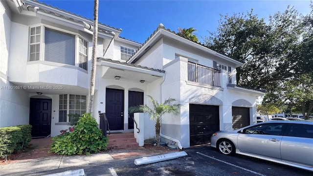 781 SW 148th Ave Unit 1513, Sunrise, FL 33325 - view of front of property with stucco siding, a balcony, a garage, and a tiled roof