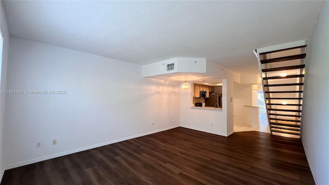 781 SW 148th Ave Unit 1513, Sunrise, FL 33325 - unfurnished living room featuring dark wood-style flooring, baseboards, and a textured ceiling