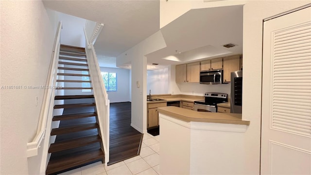 781 SW 148th Ave Unit 1513, Sunrise, FL 33325 - kitchen featuring appliances with stainless steel finishes, light tile patterned floors, a peninsula, light countertops, and a sink