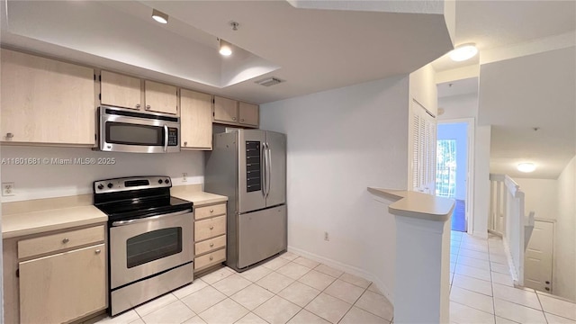 781 SW 148th Ave Unit 1513, Sunrise, FL 33325 - kitchen with appliances with stainless steel finishes, light countertops, light tile patterned flooring, a raised ceiling, and baseboards