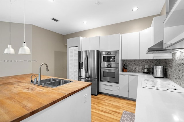 782 Lake Blvd, Weston, FL 33326 - kitchen featuring stainless steel appliances, a sink, wooden counters, tasteful backsplash, and light wood-style floors