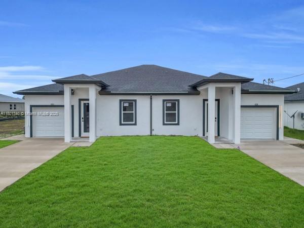 428/430 Petite Ave, Lehigh Acres, FL 33974 - prairie-style house with stucco siding, driveway, and a front yard